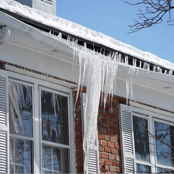 Icicles on damages gutters of house