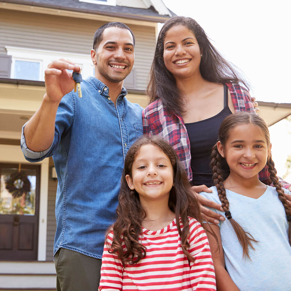 Familia frente a una casa con un juego de llaves